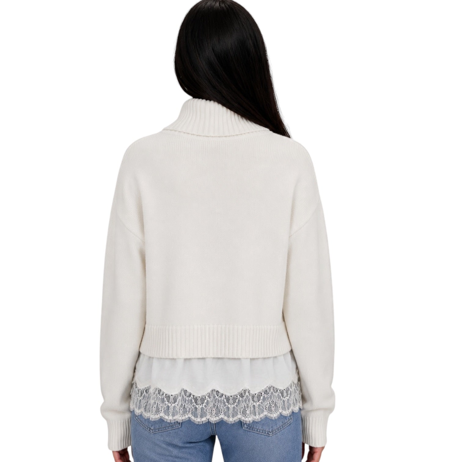 A woman viewed from the back wearing a cream-colored knit sweater with a lace hem overlay and light blue jeans, set against a plain white background.