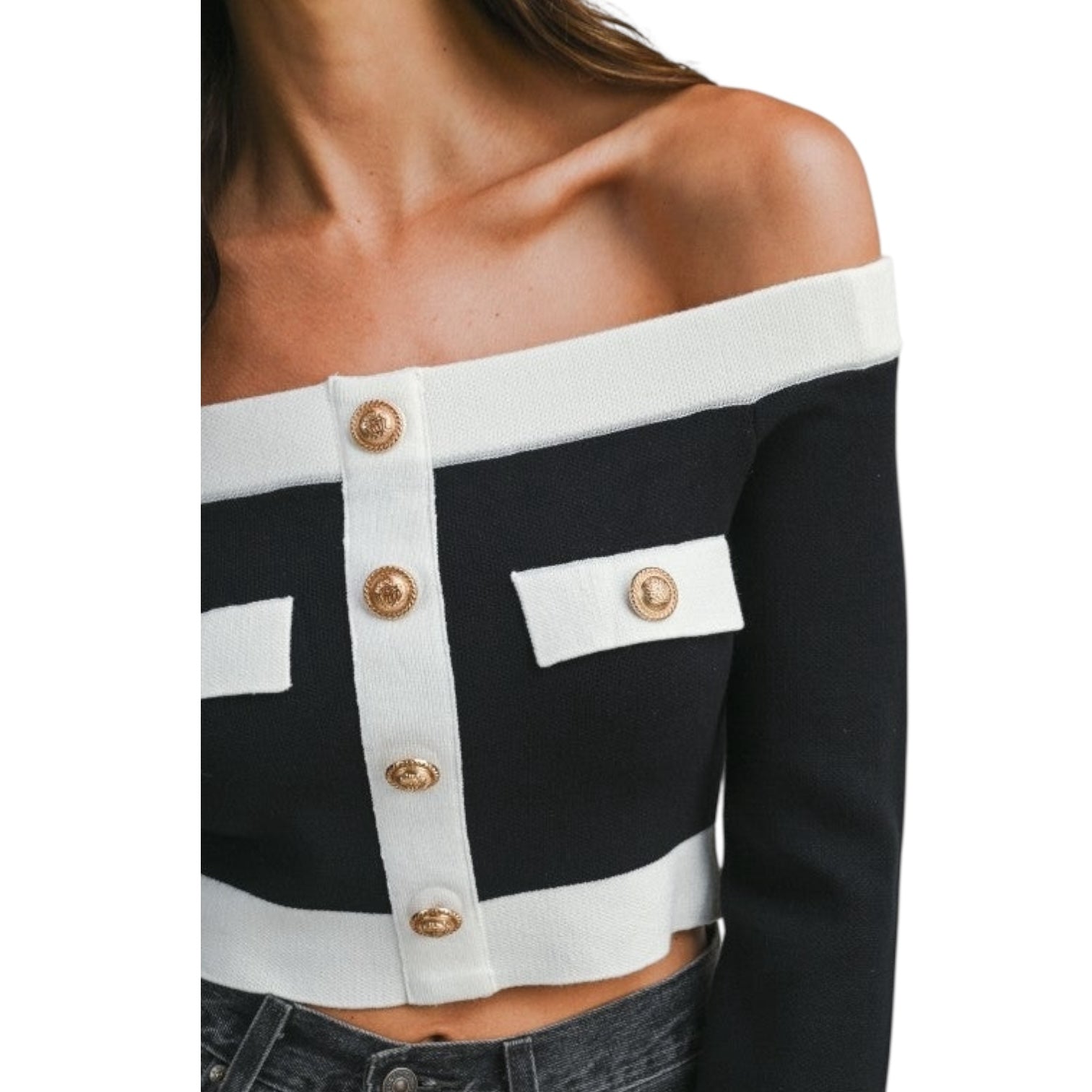 Black and white off-shoulder top with gold buttons on a white background