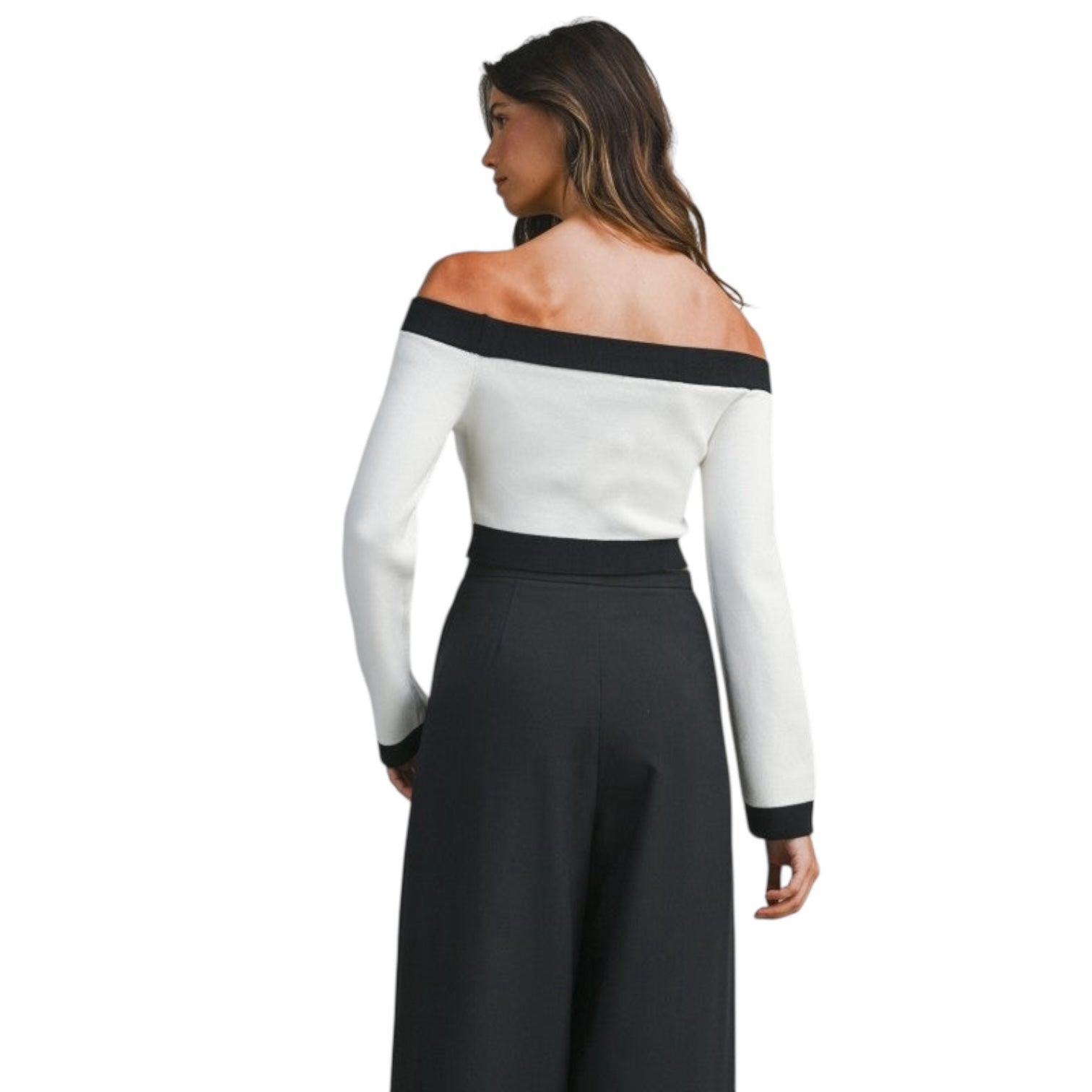 Woman wearing a white off-shoulder top with black trim and black pants on a white background