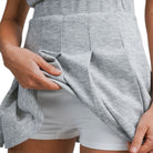 Person wearing a gray athletic outfit with a white background