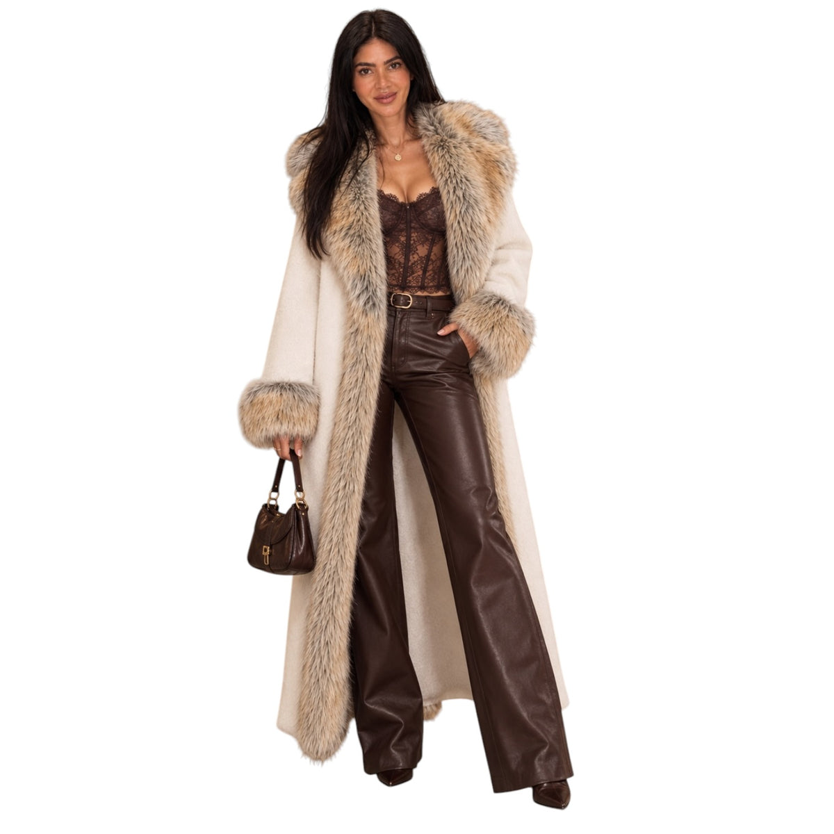 A woman modeling a long cream-colored faux fur coat with a large beige and brown faux fur collar and cuffs, styled with dark brown faux leather pants, a brown lace top, and a small brown handbag against a plain white background.
