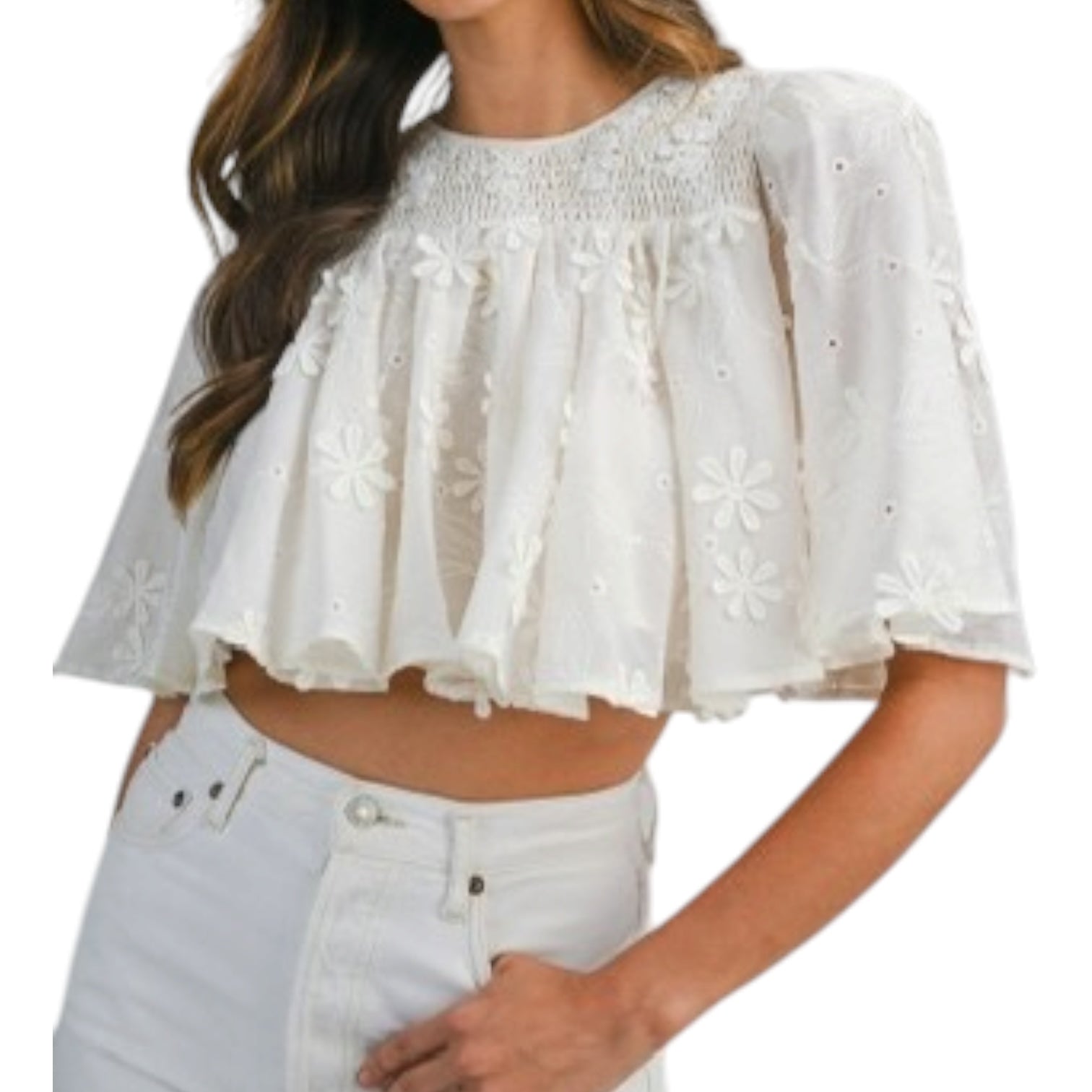 a woman wearing a cream embroidered top with white jeans