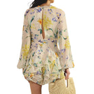 Woman wearing a floral romper with a white background