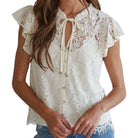 a woman wearing cream floral lace top on white background
