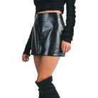Black leather skirt worn by a person on a white background