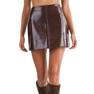 Brown crocodile-patterned skirt worn by a person on a white background