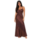 A woman modeling a floor-length satin maxi dress in a rich dark brown color, featuring diagonal lace applique panels and thin spaghetti straps, set against a plain white background.