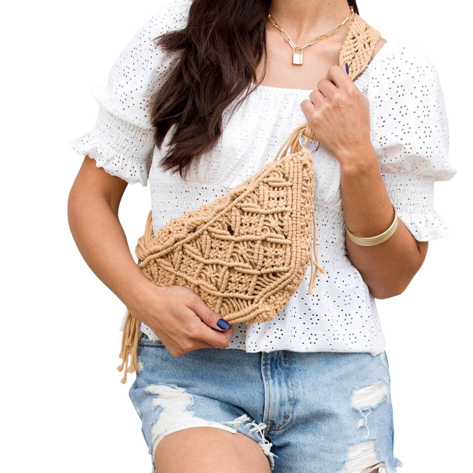 Person holding a woven beige bag against a white background