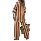 Woman wearing a brown and white striped outfit with a matching bag on a white background