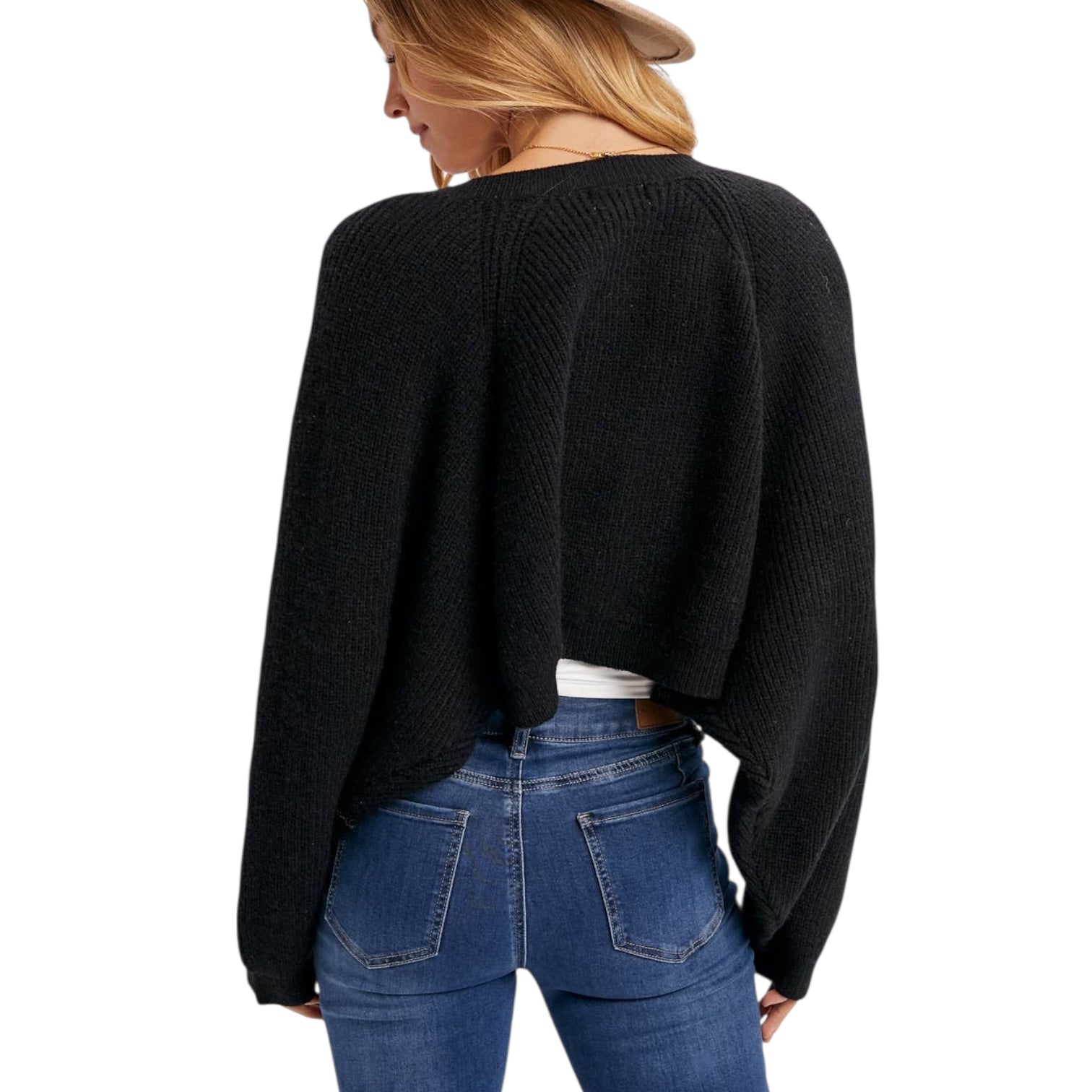 Person wearing a black sweater and blue jeans on a white background