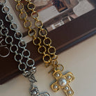 Chain necklaces with cross pendants on a white surface