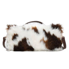 A cowhide shoulder bag with a brown and white spotted pattern and a dark brown leather handle and strap, shown against a plain white background.