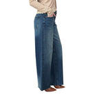 Person wearing blue wide-leg jeans on a white background