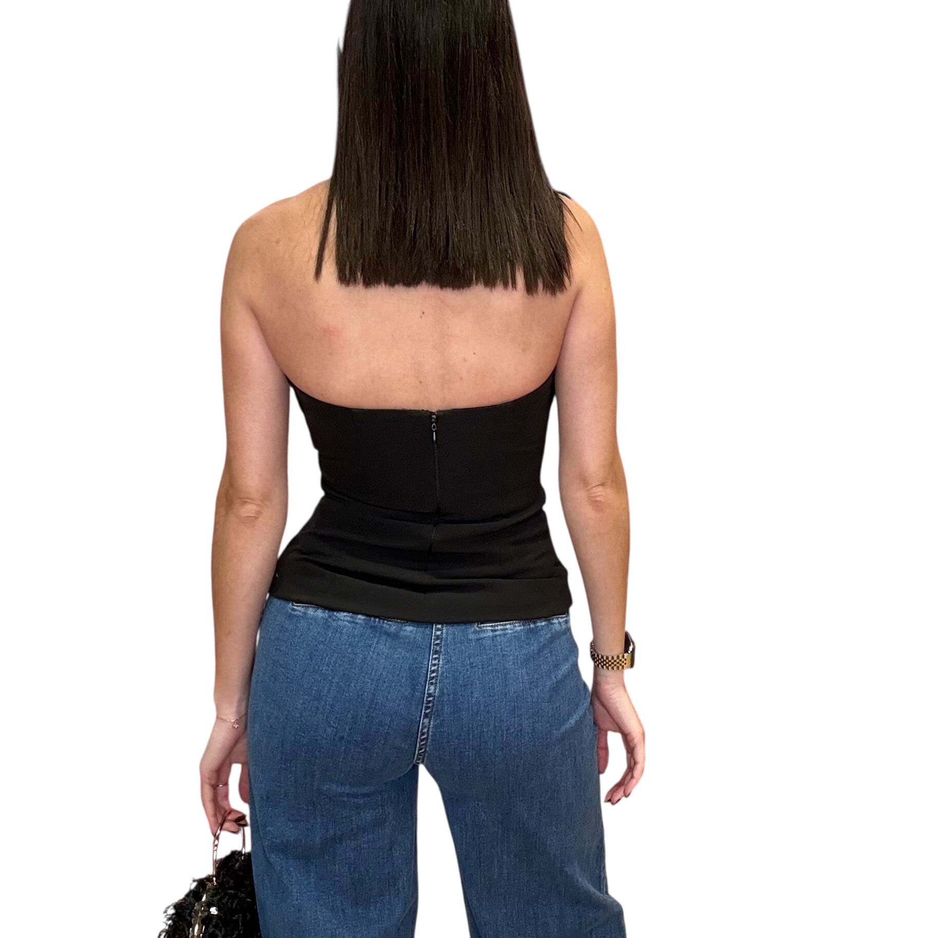 Person wearing a black halter top and blue jeans on a white background