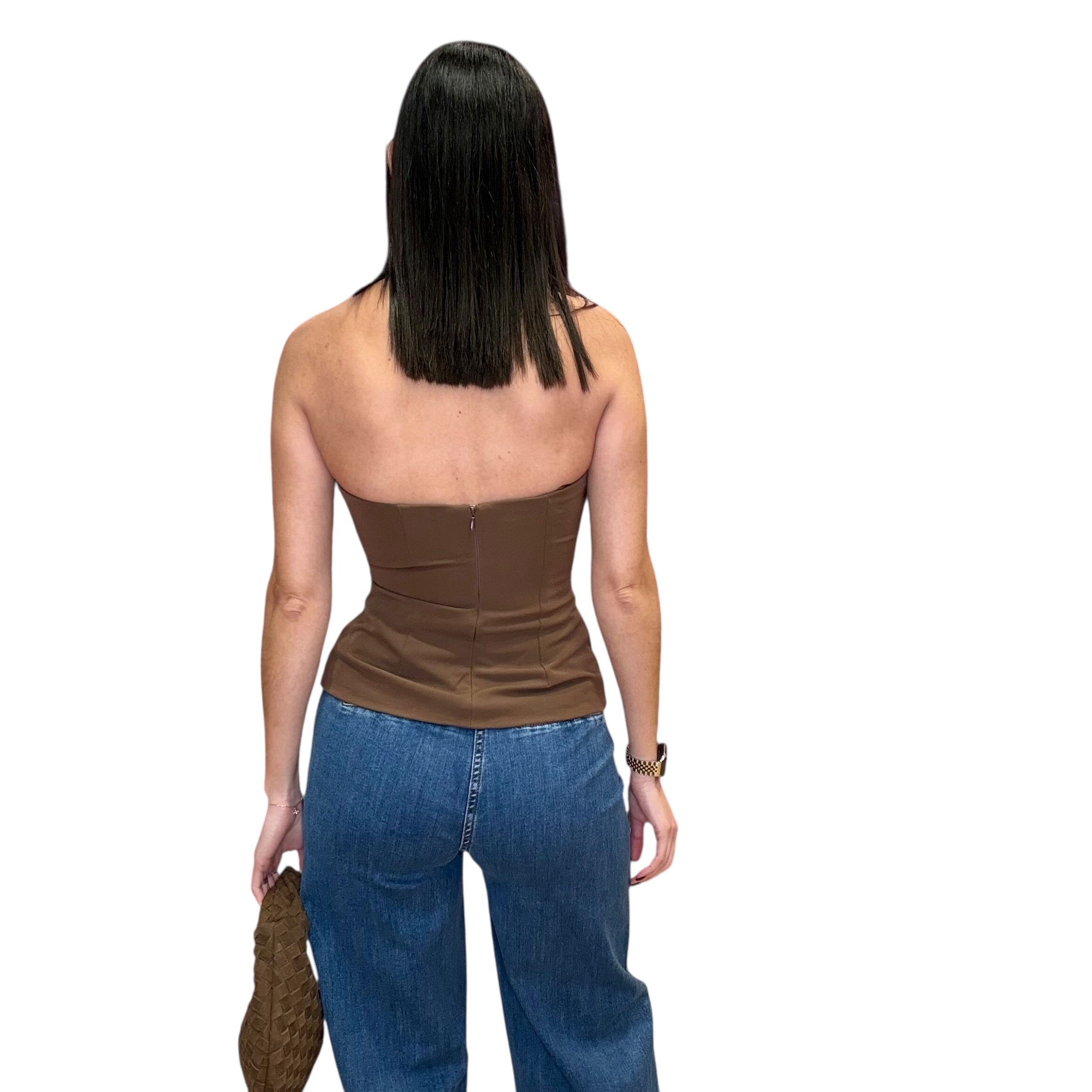Woman wearing a brown halter top and blue jeans on a white background
