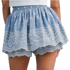 Blue lace shorts worn by a person on a white background