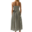 Woman wearing a denim and white striped dress on a white background