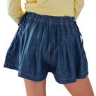 Blue denim shorts worn by a person on a white background