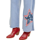 Light blue jeans with a star design and red cowboy boots on a white background