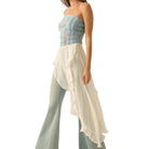 Woman wearing a strapless top and long skirt with a white background