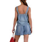 Woman wearing a denim romper on a white background