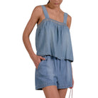 Woman wearing a denim romper with a white background