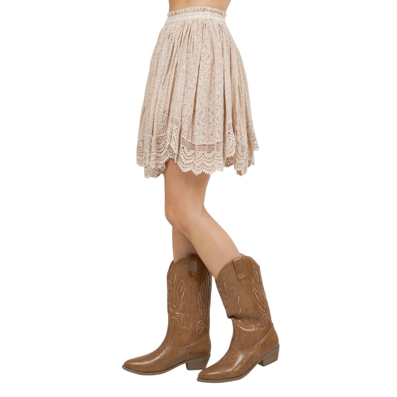 Person wearing a lace skirt and brown cowboy boots on a white background