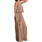 Woman wearing a beige jumpsuit on a white background