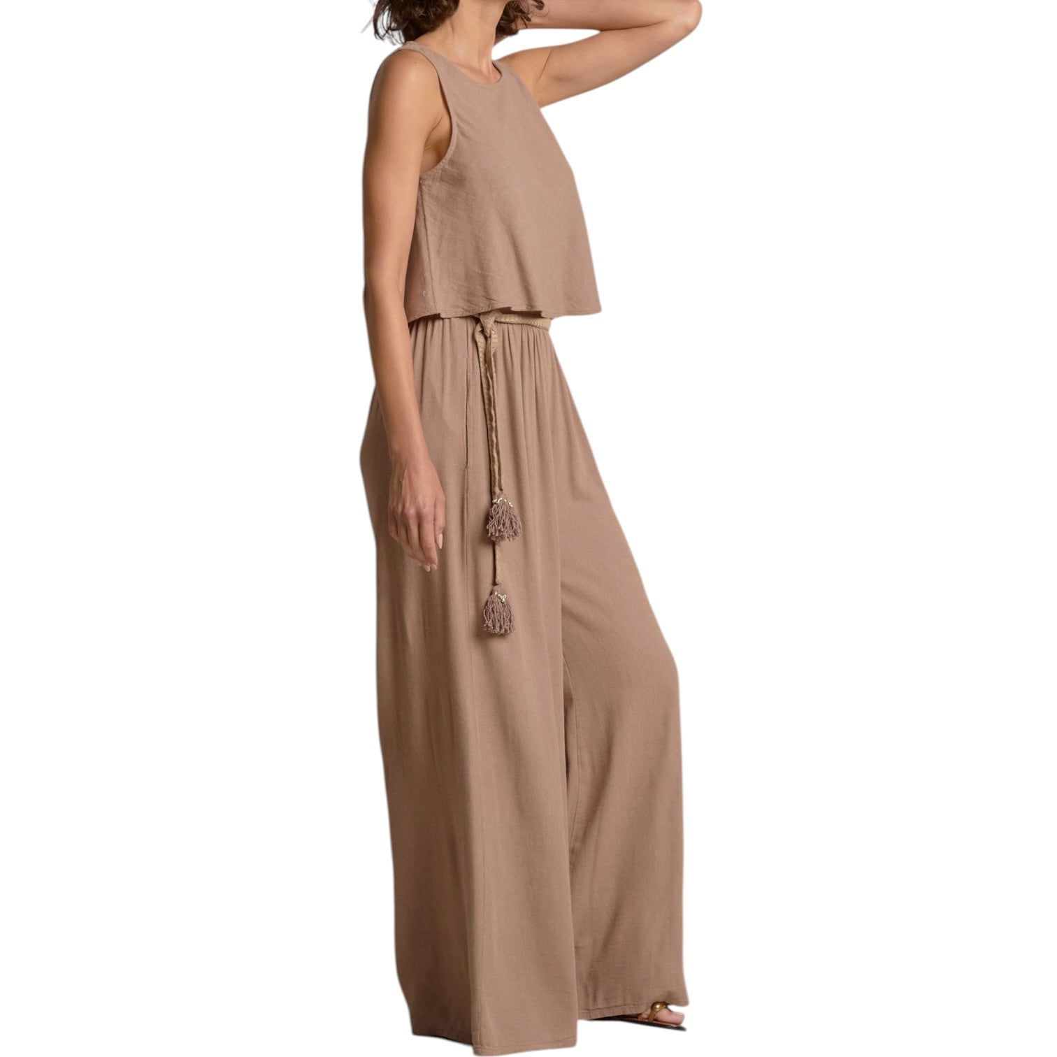 Woman wearing a beige jumpsuit on a white background