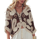 Woman wearing a brown and beige patterned crochet cardigan on a white background