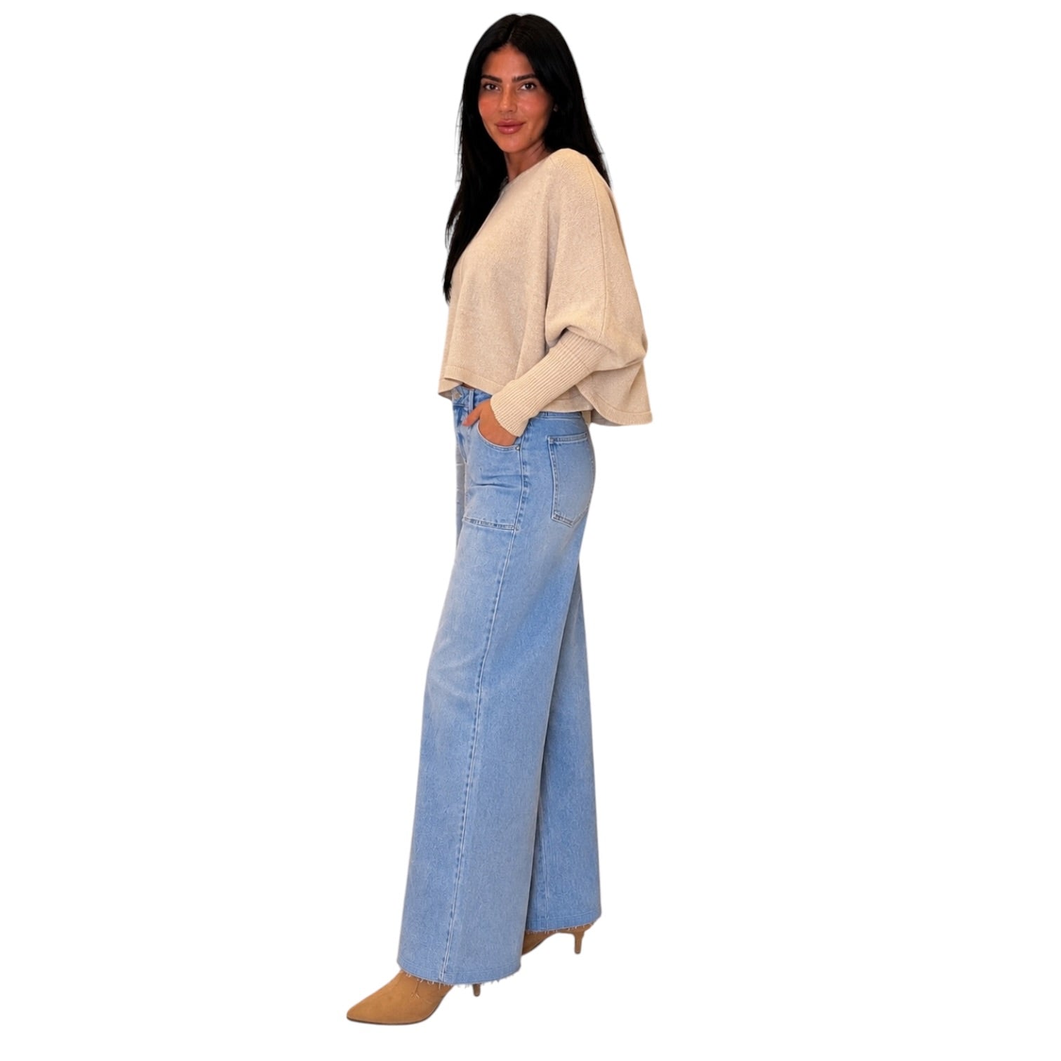 A woman modeling a light beige knit long-sleeve top and light blue wide-leg denim jeans against a plain white background.