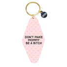 Pink keychain with text and gold ring on a white background