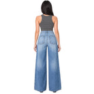 A woman shown from the back wearing a dark gray ribbed tank top and high-waisted, wide-leg blue denim jeans with a faded wash.