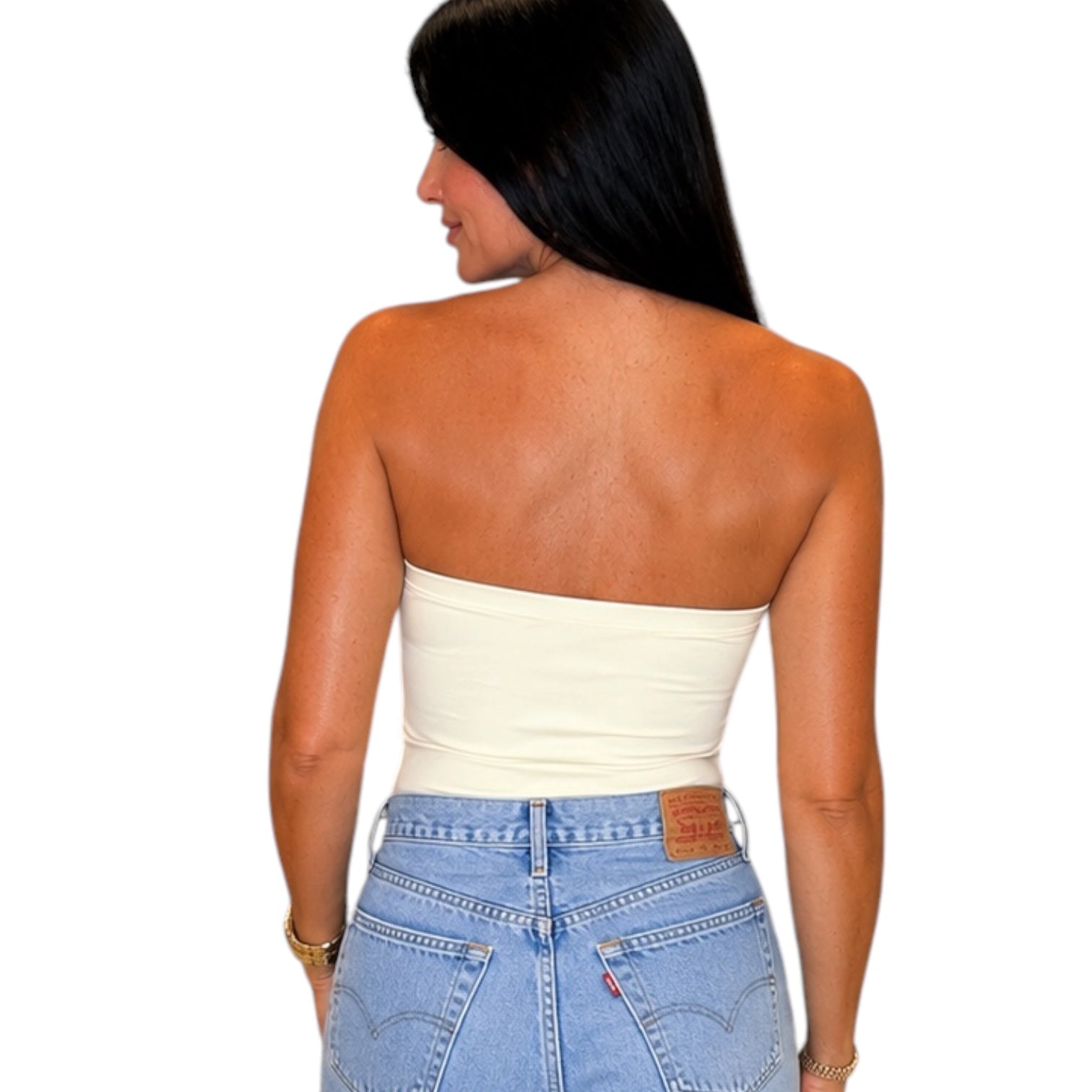 A woman shown from the back wearing a cream-colored strapless bandeau tube top and light blue jeans against a plain white background.