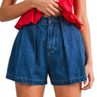 Person wearing blue denim shorts and a red top on a white background