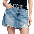 Denim skirt with distressed details worn by a person on a white background