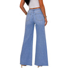 A person shown from the back wearing light blue wide-leg denim jeans with a white cropped top, photographed against a plain white background.