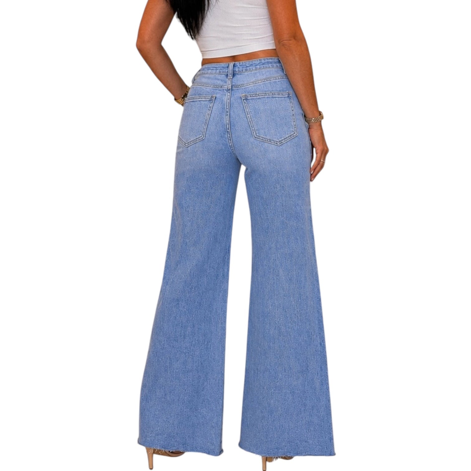 A person shown from the back wearing light blue wide-leg denim jeans with a white cropped top, photographed against a plain white background.