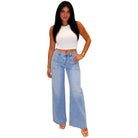 Woman wearing a white top and light blue jeans on a white background
