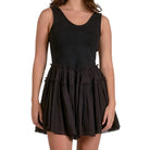 Black sleeveless dress worn by a model on a white background