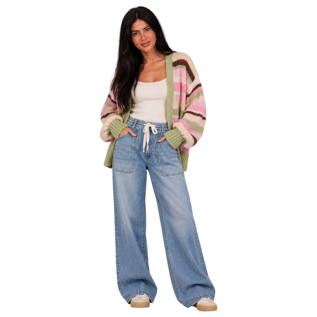 A woman modeling a striped knit cardigan with green, pink, and brown stripes over a white tank top and light blue wide-leg jeans, set against a plain white background.