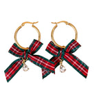A pair of gold hoop earrings with red and green plaid ribbon bows and small clear teardrop rhinestones, shown on a plain white background.