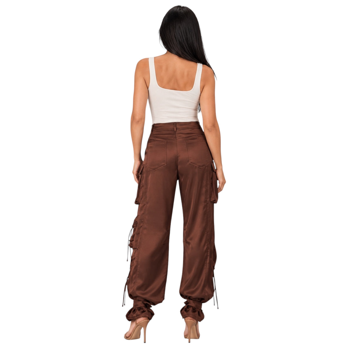 A woman shown from the back wearing brown wide-leg cargo pants with side laces, a white tank top, and nude high heels against a plain white background.