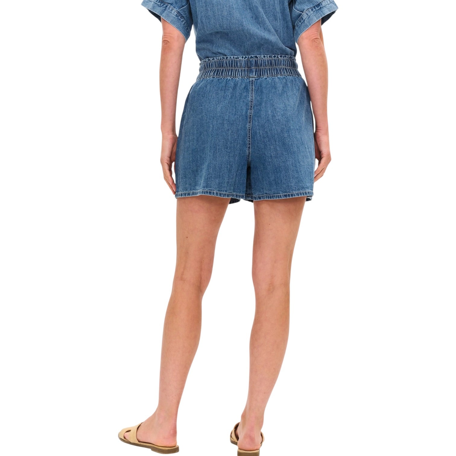 Denim shorts worn by a person on a white background