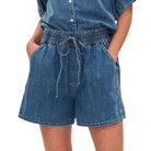 Blue denim shorts worn by a person on a white background