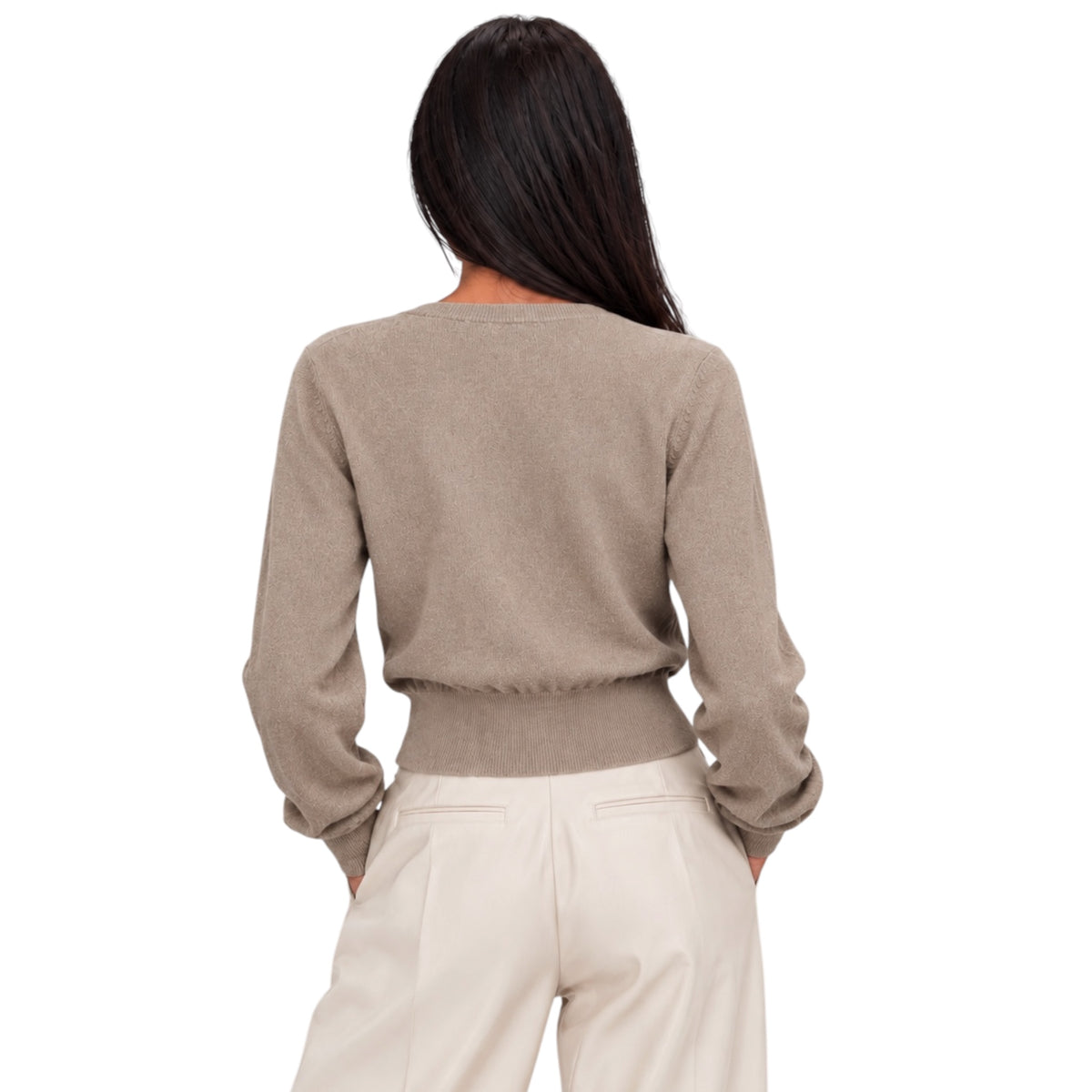 A woman shown from the back wearing a light taupe knit sweater and cream trousers against a plain white background.