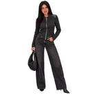 A woman modeling a dark gray zip-up long-sleeve top with shoulder patch details, paired with wide-leg dark gray jeans, holding a black woven handbag against a plain white background.