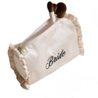 Beige makeup bag with 'Bride' text and makeup brushes on a white background
