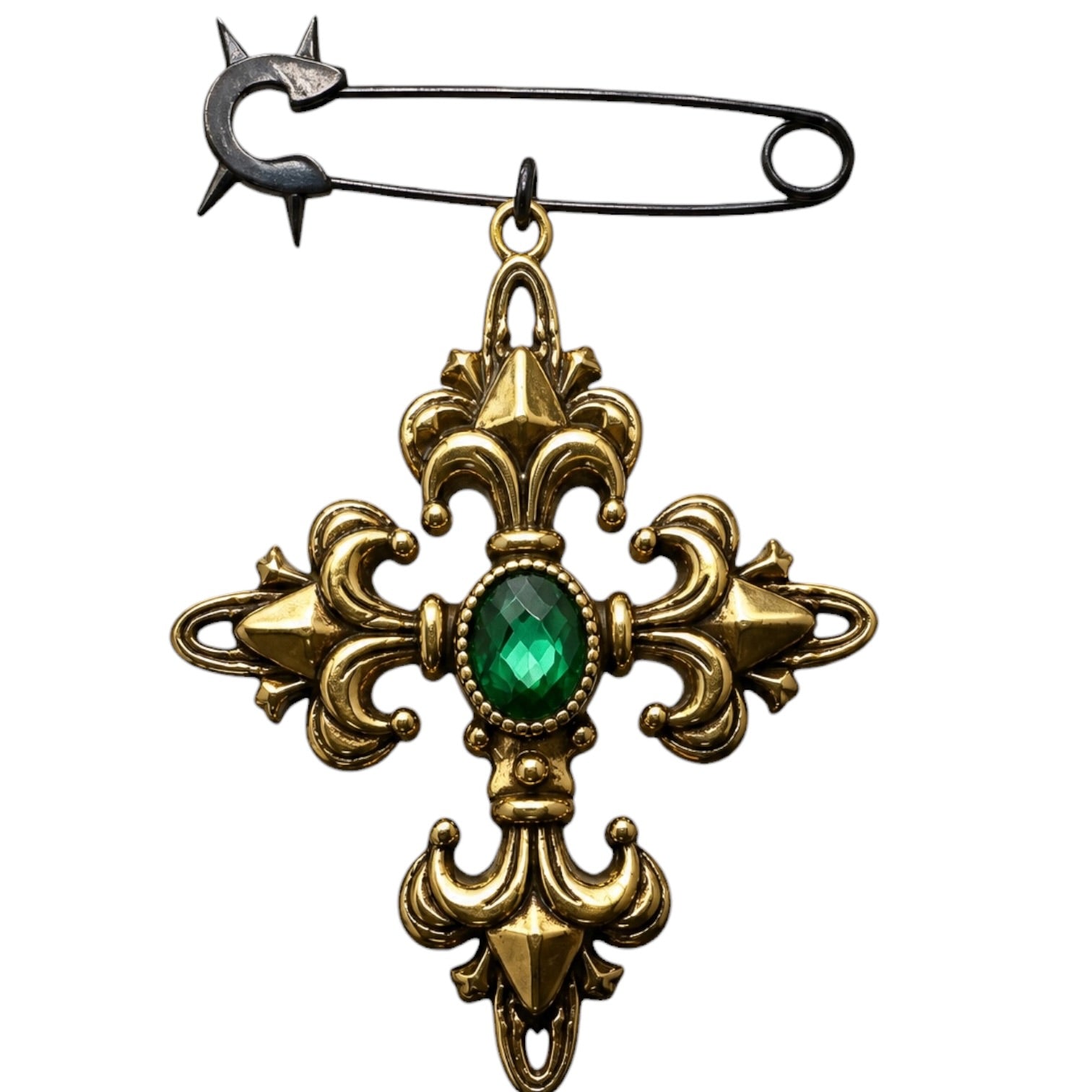 A vintage-style safety pin brooch featuring an ornate gold-toned cross pendant with a faceted green gemstone at the center, set against a plain white background.