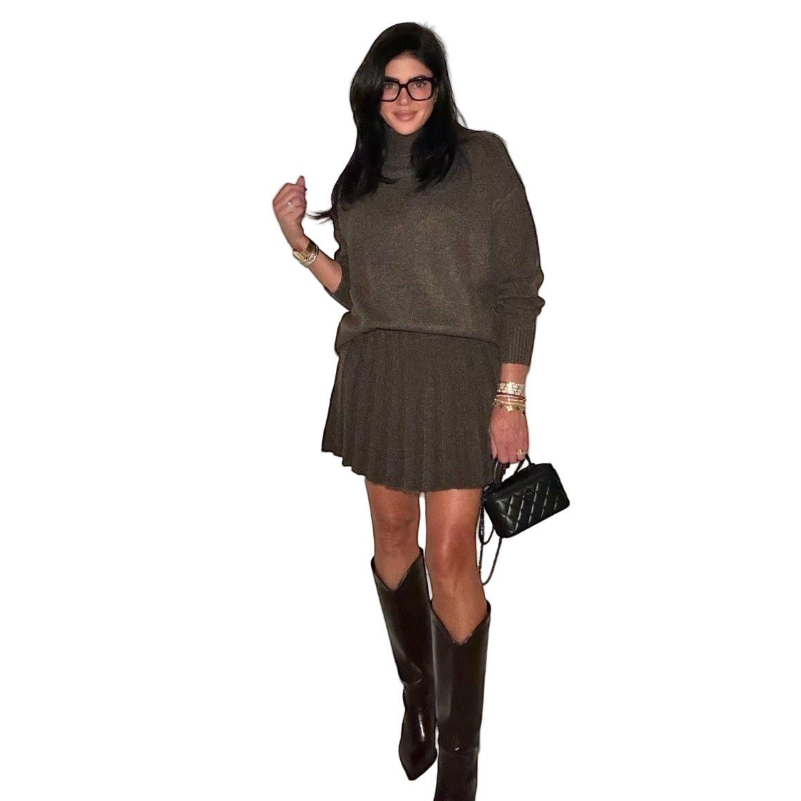 Woman wearing a brown sweater and skirt with knee-high boots indoors.